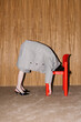 © Ulas&Merve/Stocksy - Creative Fashion Art Concept with Red Chair and Gray Outfit