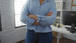 © Krakenimages.com - Young hispanic woman standing in an office with arms crossed in a confident pose wearing blue shirt and jeans
