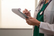 © Danil Nevsky/Stocksy - Female doctor writing medical notes on clipboard in hospital room