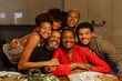 © BONNINSTUDIO/Stocksy - Happy family embracing and smiling during christmas dinner