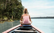 © Craig - Woman sitting on a boat in a river on an adventure into the amazon jungle in Peru, South America.