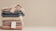 © SlashStd - Stack of folded sweaters with blank price tags on neutral background.