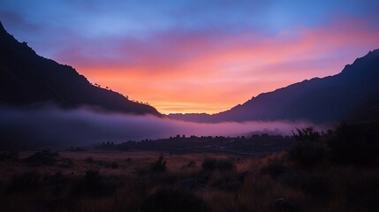 Poster - Vibrant sunrise paints the sky with orange and purple hues over a misty valley nestled between mountains.