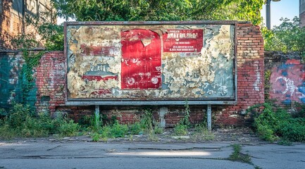 Poster - Weathered billboard with remnants of old posters on a brick wall.
