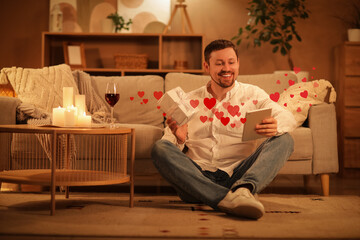 Poster - Handsome man with gift box and tablet computer having online date at home in evening