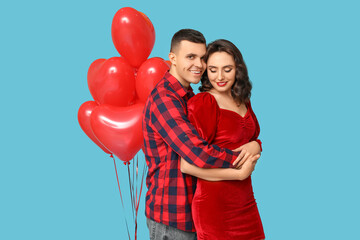 Canvas Print - Loving young couple with heart-shaped balloons on blue background. Celebration of Saint Valentine's Day