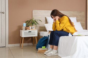 Wall Mural - Stressed female student sitting in bedroom