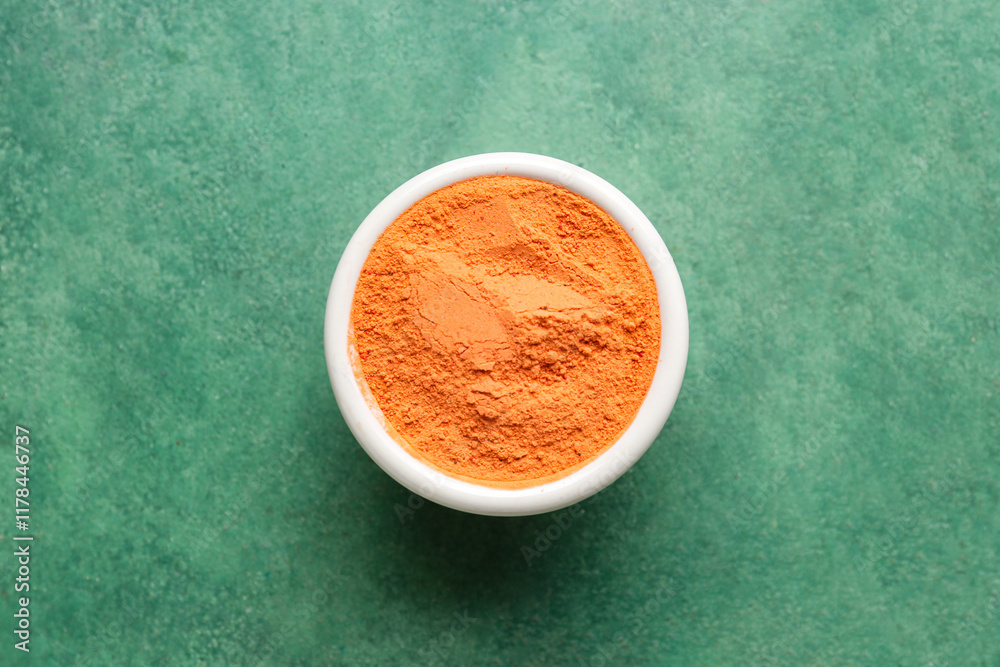 Bowl with color powder pigment on green background