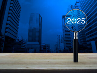 Wall Mural - 2025 start up flat icon with magnifying glass on wooden table over modern office city tower and skyscraper, Business happy new year 2025 success concept