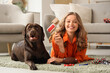 © Pixel-Shot - Young woman with pet brush and her cute dog at home