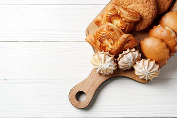 Wall Mural - Assorted baked goods arranged on a wooden serving board in a light-filled kitchen