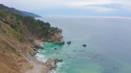 Wall Mural - Aerial view of Pacific Ocean coastline along Highway 1 in California. Big Sur, Bixby Bridge, Lucia. Travel concept, tourism, travel, vacation. 4K video.