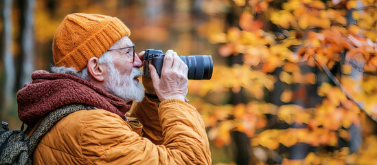 Poster - Retirement hobbies depicted through an elderly man photographing wildlife in a park Stock Photo with side copy space
