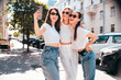 © halayalex - Three young beautiful smiling hipster female in trendy summer white t-shirt  and jeans clothes. Sexy carefree women posing in street. Positive models having fun, going crazy. In sunny day, take selfie