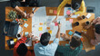 © Summit Art Creations - Top down aerial view of business team making scrum task board at meeting room. Group of people writing at paper and sticky notes for making kanban board to manage work flow. Top view. Convocation.