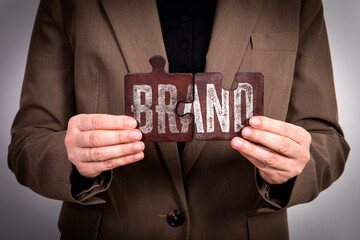Canvas Print - BRAND Concept. Business woman with wooden puzzle pieces