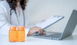 © Lucky7Trader - Pill bottles in front of the doctor record the patient's health examination results, medication usage, healthcare, and medical checkup concepts