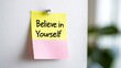 © Artyom - Yellow and pink sticky note with motivational quote pinned to wall