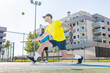 © ivan - Two men playing pickleball on a court, one lunging to hit the ball