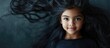 © The 2R Artificiality - Smiling young girl with long black hair, playing coyly with one eye visible, against a dark backdrop with ample copyspace for text.