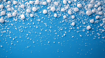 Festive blue background with scattered white balls and crystals, winter holidays concept.