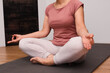 © Trik - Woman practicing breathing exercise. Hand, lotus pose. Woman on a floor for yoga, mediation and zen. Woman Practicing Yoga Indoors.