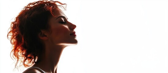 Wall Mural - Silhouetted Profile of a Young Woman with Curly Red Hair Against a Bright White Background Creating Ample Copyspace for Text Usage