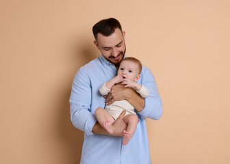 Wall Mural - Father with his cute baby on beige background