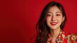© Danudet.C - Young woman with long hair wearing a vibrant floral shirt and bright red lipstick, smiling cheerfully against a bold red background for a lively and festive atmosphere.