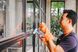 © Suphakant - people doing cleaning are using cloths and spraying disinfectant Wipe the glass in the office room. cleaning staff.cleaning maid