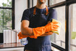 © Suphakant - male cleaning staff Hold wipes and a bottle of disinfectant spray. and cleaning equipment
