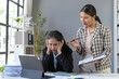 © amnaj - Manager scolds stressed employee at desk, highlighting workplace tension. Papers and laptop emphasize office environment and pressure