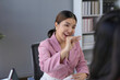 © amnaj - Asian businesswoman gesturing and speaking with colleague during a meeting in modern office
