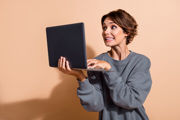 Poster - Photo of ecstatic eccentric funny woman dressed grey pullover play excited video game on laptop isolated on pastel color background