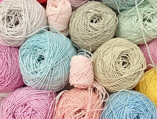 Colorful pastel yarn balls in various shades are arranged together, inviting creative expression in knitting and crafting activities