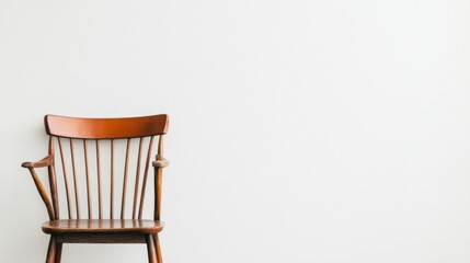 Simple wooden chair against white wall.