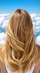 A woman with long blonde hair standing in front of a blue sky