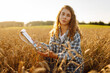© maxbelchenko - A woman farmer in a wheat field checks the harvest, quality. Agriculture food industry. Rich harvest.