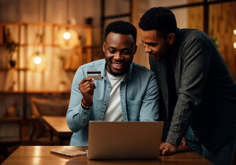 Poster - Two men are making an online payment using a credit card and a laptop in a cafe