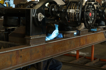 Poster - Welding operation on railway components in a busy manufacturing facility