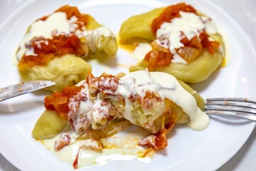 Wall Mural - Classic Ukrainian food, perohê or veréneki stuffed with potatoes and cottage cheese and cooked, served with different types of sauce and salted and sour cream