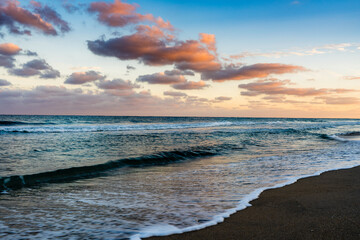 Wall Mural - sunset over the sea with waves crashing on beach