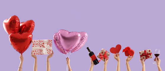 Wall Mural - Female hands with gift box and balloons on lilac background. Valentine's Day celebration