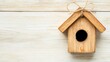 © Pojjanee - Rustic wooden birdhouse with a cute design and natural twine bow on light wooden background