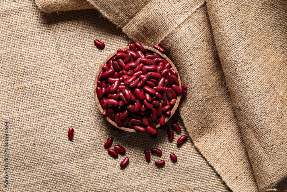 Bowl with raw beans on burlap fabric