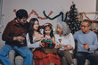 © ARMMY PICCA - Portrait of Asian family exchanging presents during christmas at home. Attractive happy people holding gift box, celebrate holiday thanksgiving, xmas eve tradition in living room in house together.