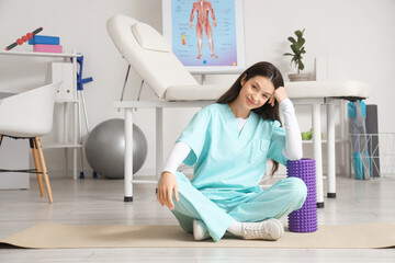 Sticker - Female physiotherapist with foam roller  in rehabilitation center