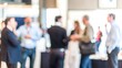 © Jo - Annual Business Meetup Blur – A blurred scene of an annual business meetup with colleagues interacting.