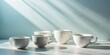 © Autun - Clean lines, minimalist white ceramic cups. Studio still life, side view, pristine background.