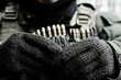 © smth.design - Soldier holding ammunition belt with tactical gloves